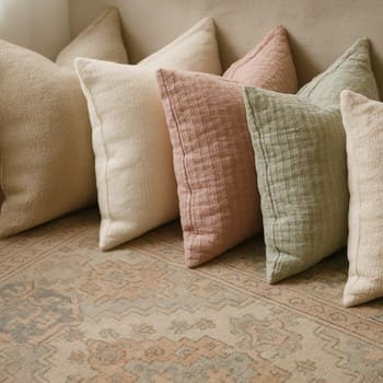 Renk and tonlarına göre sıralanmış dekoratif yastık ve kilim kombini