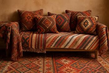 Aynı odada kilim, plaid ve dekoratif yastıkların katmanlı kullanımı